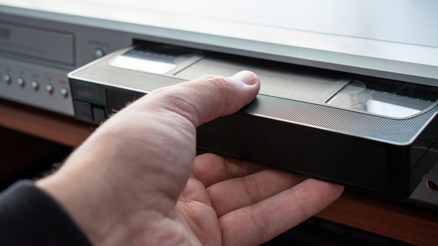 Close-up of inserting a VHS tape into an old VCR