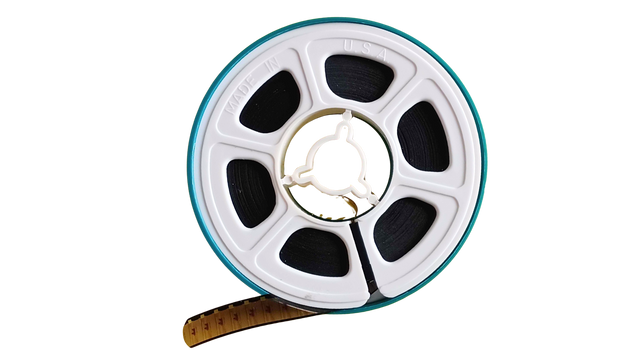 8mm film reel with a small amount of film exposed on a white background