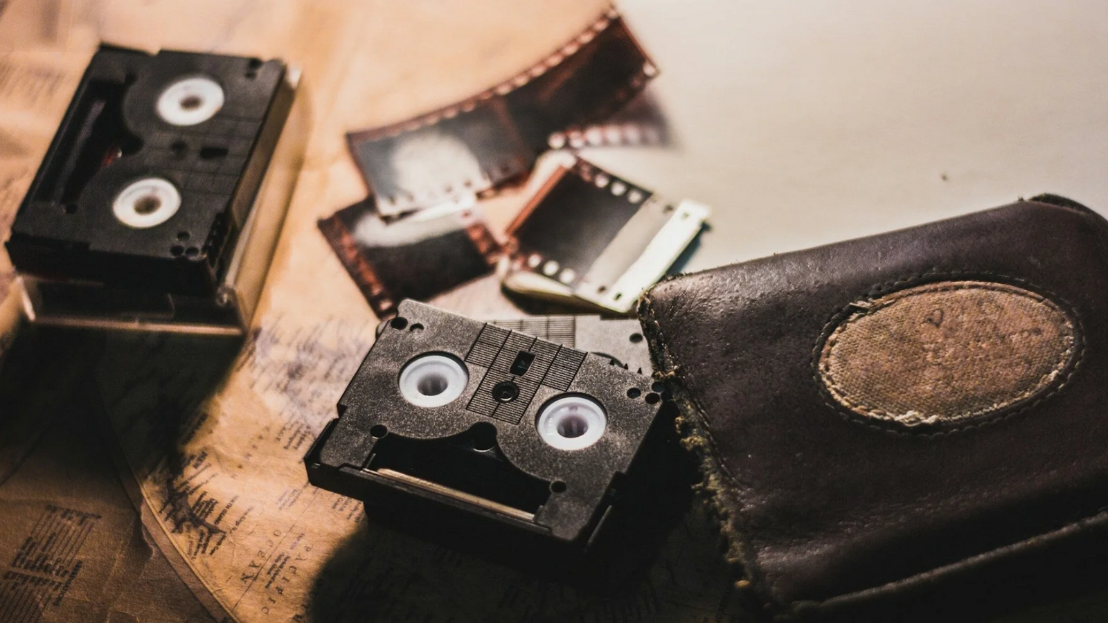 A cluttered desk with VHS tapes and old photo albums