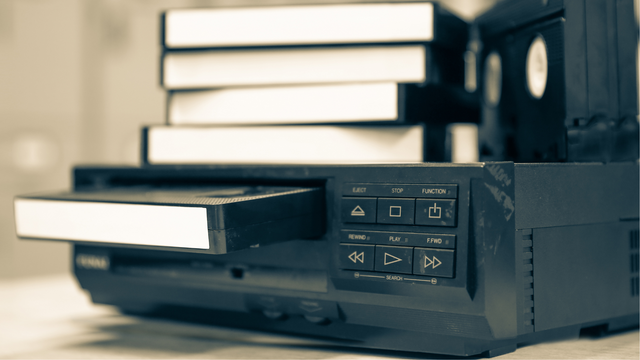 VHS conversion setup with VCR and tapes needing digitizing