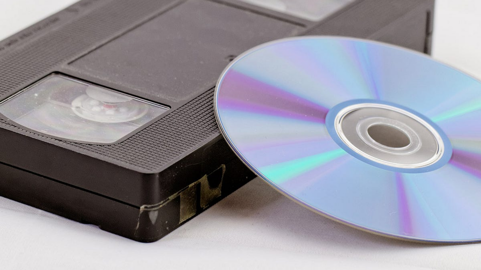 VHS tape and scratched DVD showing need for digital conversion