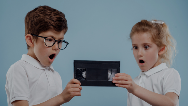 Boy and girl looking at old VCR tapes