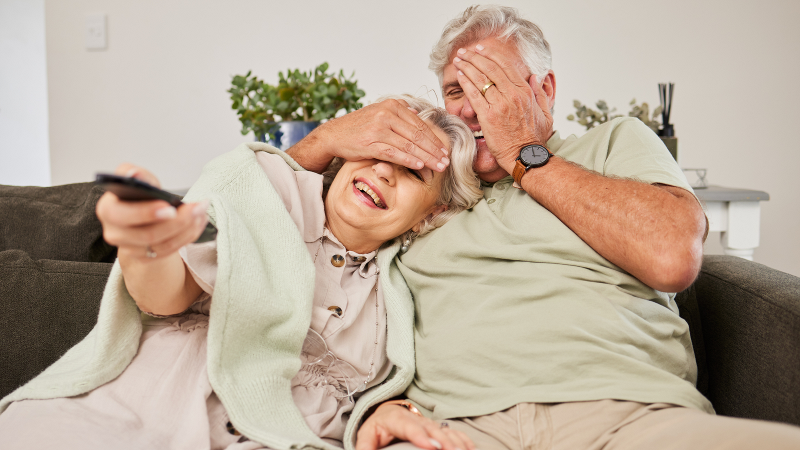 Couple celebrating 40 year anniversary watching digitized wedding video with family