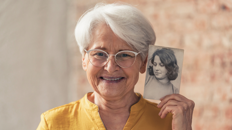 Elder Woman Holding Old Photo of Herself