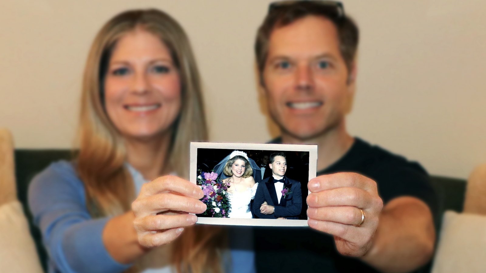 Married couple holding old wedding photo to be scanned at 600 DPI