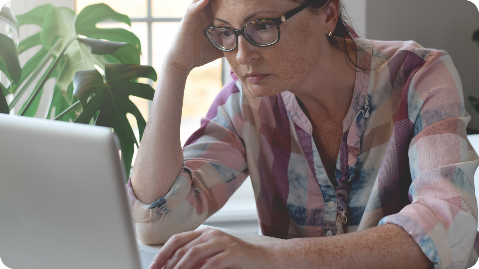 Woman looking at laptop upset about the true Legacybox cost