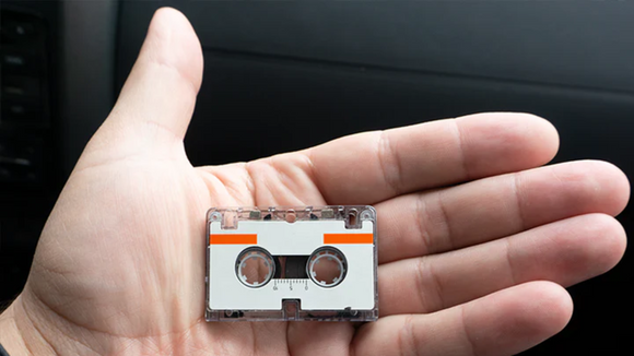 Audio Microcassette in a Human Hand