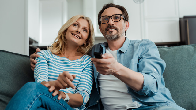 Couple celebrating 20 year anniversary watching digitized wedding video