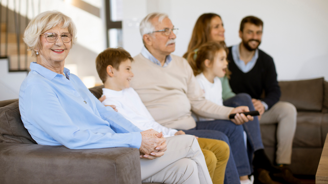 Family watching old VCR tapes converted to digital on a modern screen