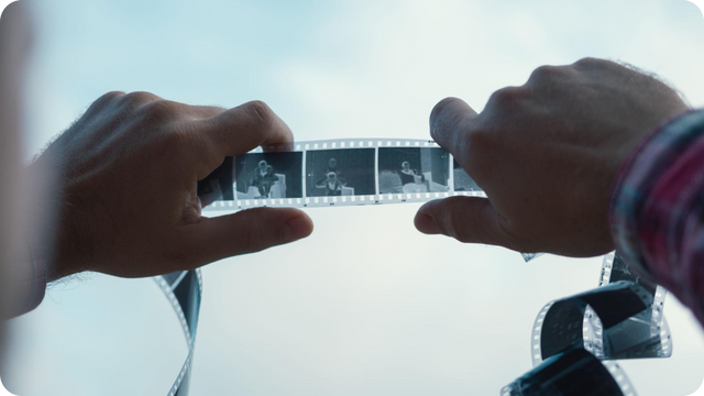 Man looking at reversed images on a photo negative strip