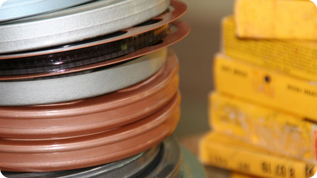 Vintage Super 8mm film reels stored in metal canisters and boxes