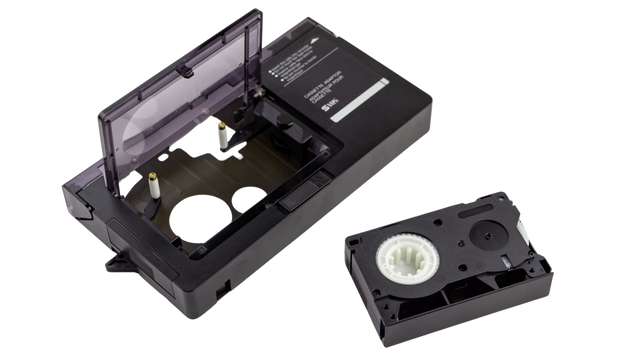 A side-by-side of a compact VHS-C cassette and its adapter
