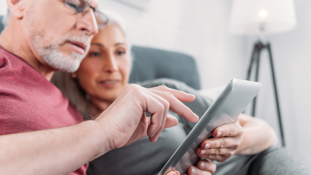 Husband and wife looking through preserved family photos together, representing a meaningful Valentine’s Day gift from Heirloom