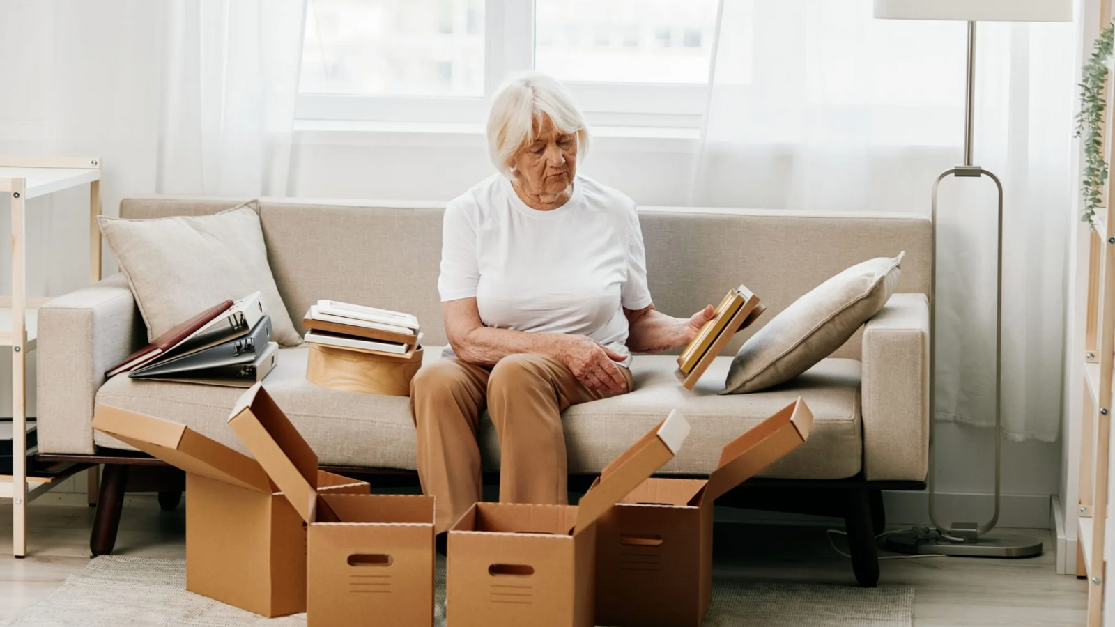 woman sorting through old boxes of memories at home